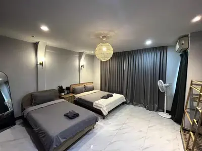 a bedroom with two beds and a chandelier at 4BR 12PAX 7min walk to Samitivej Sukhumvit Hospital in Khlong Toei