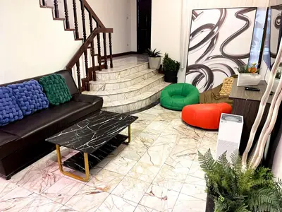 a lobby with a couch and a table and stairs at 4BR 10PAX Ensuite Near EmQuartier Emporium Emsphere in Khlong Toei