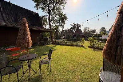 a yard with chairs and a table and a grass field at The Grand Imperial in Ban Song Hong