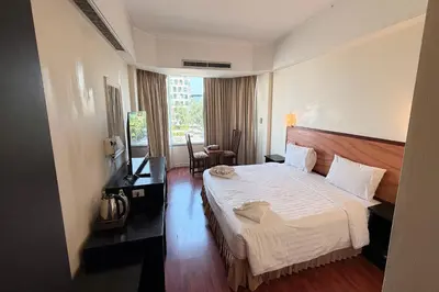 a hotel room with a large bed and a window at The Grand Imperial in Ban Song Hong