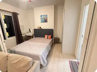 a bedroom with a bed and a chair and a table at Chapter One Eco Ratchada-HuaiKhwang in Bangkok