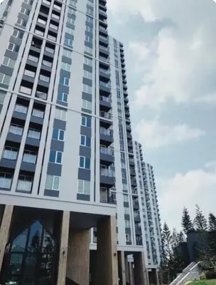 a tall apartment building with a sky at Chapter One Eco Ratchada-HuaiKhwang in Bangkok