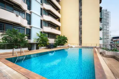 a swimming pool in front of a building at KingBed|BTS&Park»5min|ParkView|Gym|Washer|FastWiFi in Khlong Toei