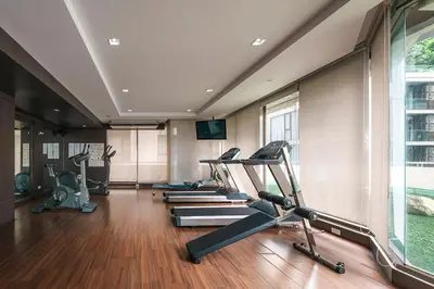 a gym with several treadmills and elliptical machines at KingBed|BTS&Park»5min|ParkView|Gym|Washer|FastWiFi in Khlong Toei