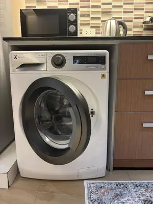 a washing machine with a microwave on top of it at KingBed|BTS&Park»5min|ParkView|Gym|Washer|FastWiFi in Khlong Toei