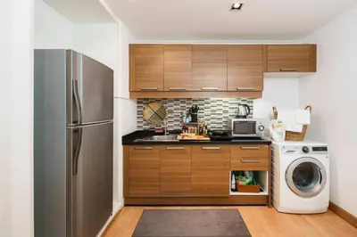 a kitchen with a refrigerator and a washing machine at Quiet Asoke/Nana BTS Retreat w/ Skyline & Gym/Park in Khlong Toei