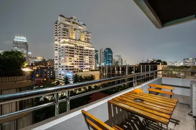 a balcony with a wooden bench and a city skyline at Quiet Asoke/Nana BTS Retreat w/ Skyline & Gym/Park in Khlong Toei