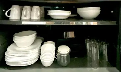 a shelf filled with white plates and bowls at Impact Arena & DMK - 4BR 12pax Home 55
