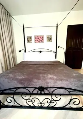 a bedroom with a large bed with a metal frame at Impact Arena & DMK - 4BR 12pax Home 55