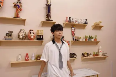 a young boy standing in a room with vases at Moochi Home Ratchada in Bangkok
