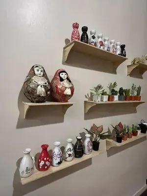 a bunch of vases on shelves on a wall at Moochi Home Ratchada in Bangkok
