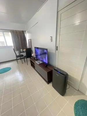 a living room with a tv and a table with chairs at Lazy Ma-fia C3 Andy in Ban Song Hong