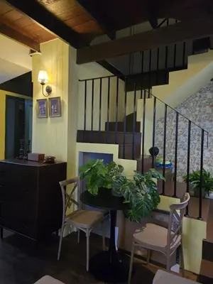 a dining room with a table and chairs and a fireplace at Carl and Ellie Home in Bangkok