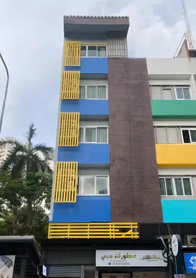 a tall building with yellow windows on the side of it at XX Oh My Nap BTS NANA in Makkasan