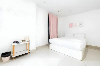 a white bedroom with a bed and a table at XX Oh My Nap BTS NANA in Makkasan