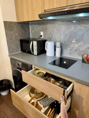 a kitchen with a counter with a stove top oven at Common Living Ekkamai in Bangkok