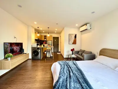a bedroom with a bed and a living room at Common Living Ekkamai in Bangkok