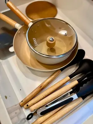 a frying pan and other cooking utensils in a drawer at Common Living Ekkamai in Bangkok