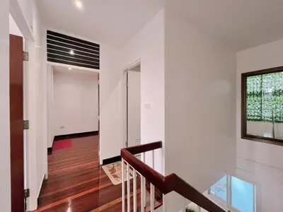 a staircase in a house with white walls and a window at MRT-Accessible & Delightful Family Hub! in Bangkok