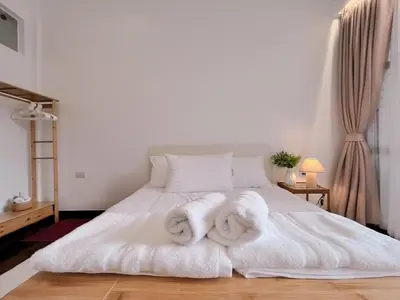 a bedroom with two towels on a white bed at MRT-Accessible & Delightful Family Hub! in Bangkok