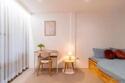 a bedroom with a bed and a table and a desk at MRT-Accessible & Delightful Family Hub! in Bangkok