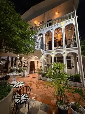 a large building with chairs and plants in a courtyard at Bangkok Neighborhouse in Bangkok