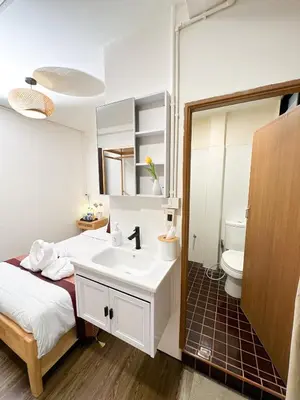 a bathroom with a bed and a sink and a toilet at Bangkok Neighborhouse in Bangkok