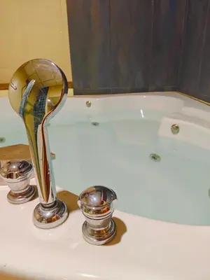 a shower head and two bowls on a bathroom sink at At Sathon apartment in Bangkok