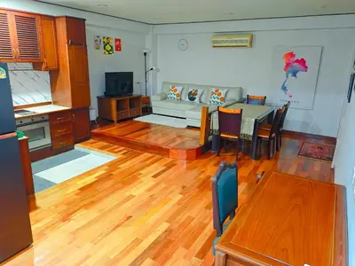 a kitchen and living room with a table and a couch at At Sathon apartment in Bangkok