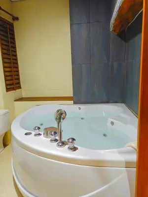 a bath tub with a faucet in a bathroom at At Sathon apartment in Bangkok