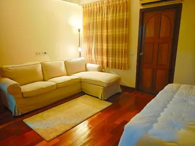 a living room with a couch and a bed at At Sathon apartment in Bangkok