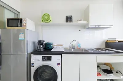 a kitchen with a refrigerator and a washing machine at Downtown Spacious Luxury Condo BKK- 5 mins BTS! in Bangkok