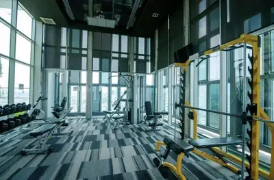a gym with treadmills and machines in a room with windows at Downtown Spacious Luxury Condo BKK- 5 mins BTS! in Bangkok