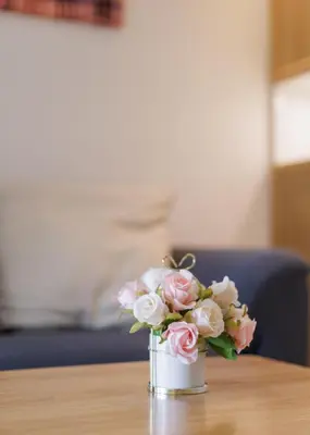 a vase filled with pink roses sitting on a table at Downtown Spacious Luxury Condo BKK- 5 mins BTS! in Bangkok