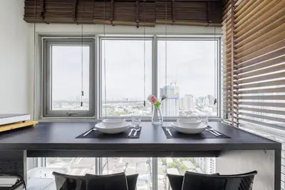 a dining room table with a view of the city at Downtown Spacious Luxury Condo BKK- 5 mins BTS! in Bangkok