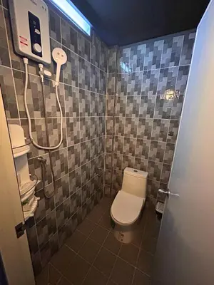 a bathroom with a toilet and a shower at Munchies Bed & Breakfast in Bangkok