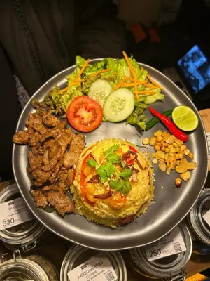 a plate of food with meat and vegetables on a table at Munchies Bed & Breakfast in Bangkok