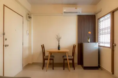 a dining room with a table and a refrigerator at Monument Stay in Bangkok