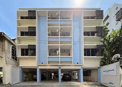 an apartment building with a parking lot in front of it at Monument Stay in Bangkok