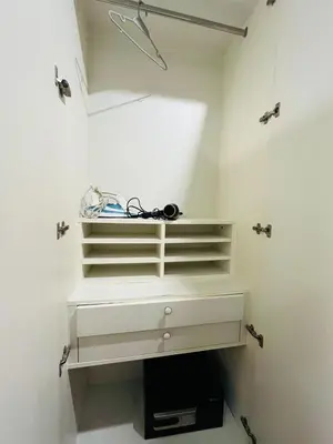 a closet with white shelves and a hanger at Thong Lor Luxury condo with Swimming Pool, Fast Wifi in Sathani Khlong Tan