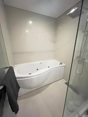 a white bath tub in a bathroom with a shower at Thong Lor Luxury condo with Swimming Pool, Fast Wifi in Sathani Khlong Tan