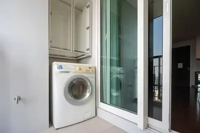 a washing machine in a kitchen next to a window at Thong Lor Luxury condo with Swimming Pool, Fast Wifi in Sathani Khlong Tan