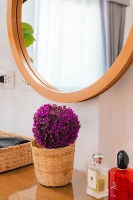 a basket of purple flowers in front of a mirror at EXCLUSIVE SUKHUMVIT RESIDENCE, 3 Min BTS, Thonglor, 20 Guests in Bangkok