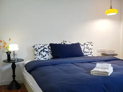 a bedroom with a blue bed and a lamp at Cozy home with car parking near MRT Lat Phrao & Phawana in Bangkok
