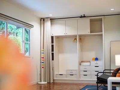 a room with white cabinets and a window at Cozy home with car parking near MRT Lat Phrao & Phawana in Bangkok