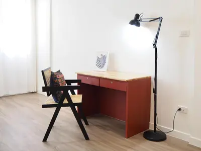a desk with a chair next to a lamp at Cozy home with car parking near MRT Lat Phrao & Phawana in Bangkok