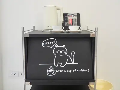 a chalkboard with a cat on a cup of coffee at Cozy home with car parking near MRT Lat Phrao & Phawana in Bangkok