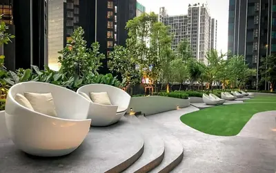 a row of white chairs sitting on a patio at Life asoke rama 9 in Bangkok