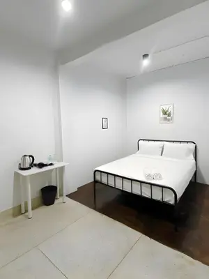 a white bedroom with a bed and a table at xx BAO The Giant Swing - เสาชิงช้า ศาลเจ้าพ่อเสือ 1 in Bangkok