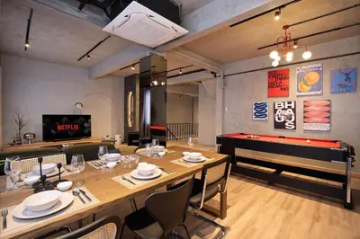 a dining room with a table and a pool table at Townhouse at Sathu Pradit road in Bangkok